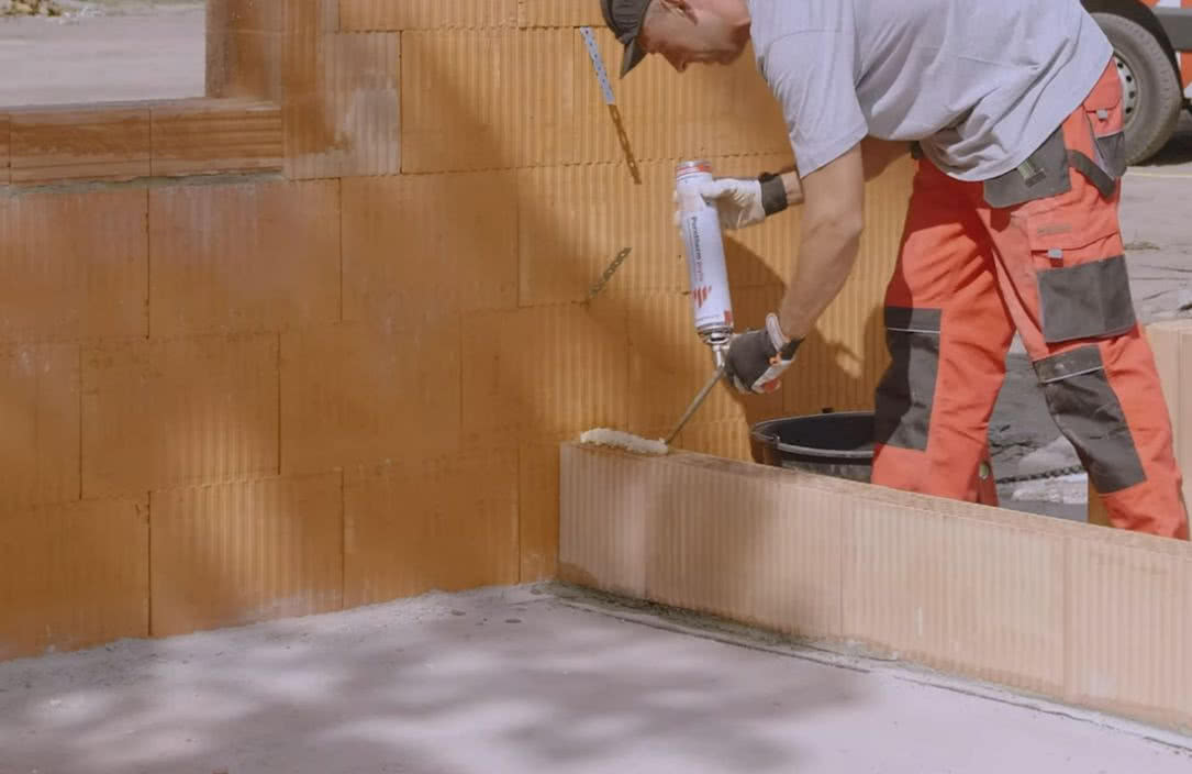 Wznoszenie ścianki działowej z pustaków ceramicznych poryzowanych Porotherm z wykorzystaniem pianki Dryfix. fot. Wienerberger